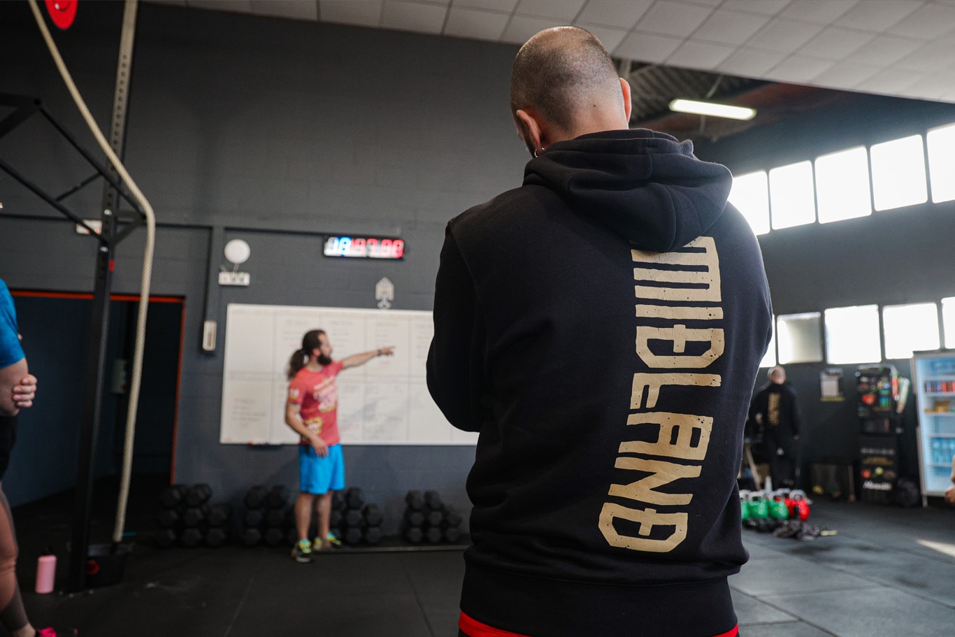 Coach de Midland CrossFit señalando la pizarra durante la planificación del entrenamiento